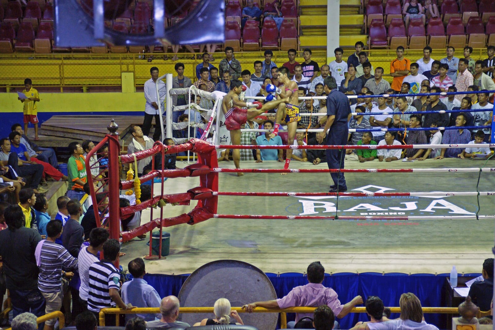 Muay Thai fighters in the ring at a Thai provincial boxing stadium